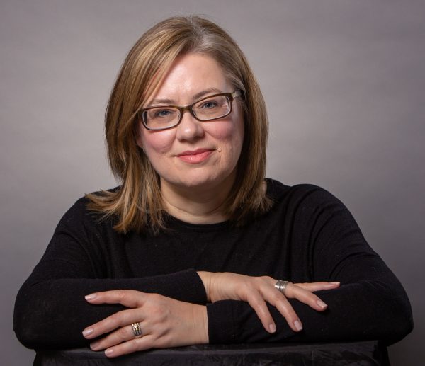 Headshot of Jennifer. A white woman with blonde hair wearing black glasses with thick lenses.