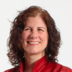 Photo of Pina. A smiling woman with wavy brown hair.